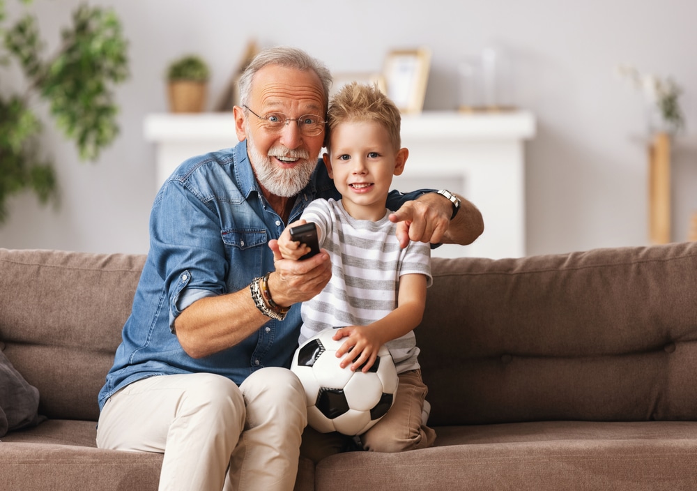 grandpa watching tv with grandkid