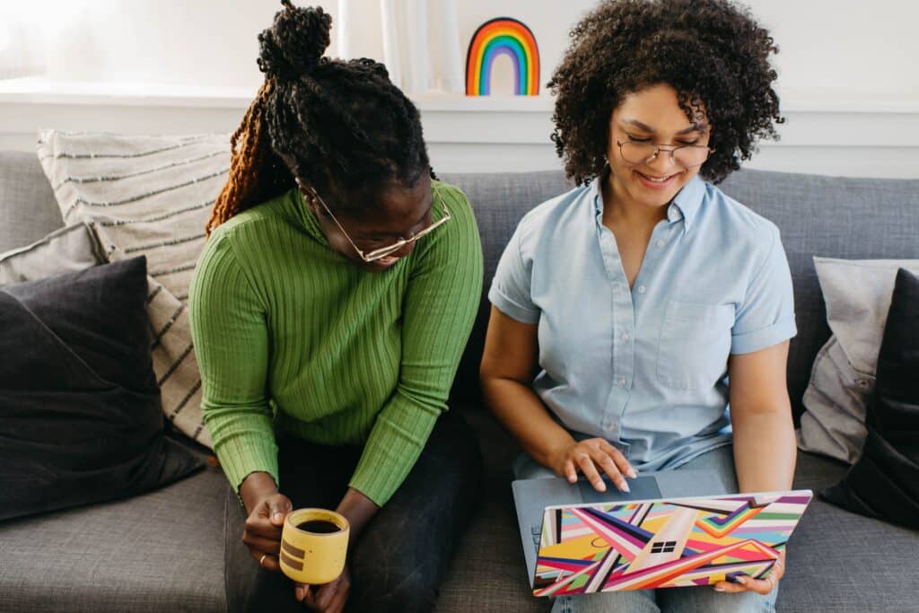 two-women-looking-at-laptop-and-smiling