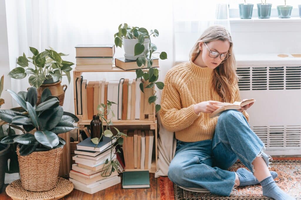 woman-reading-on-the-floor-with-low-bookshelf-beside-her