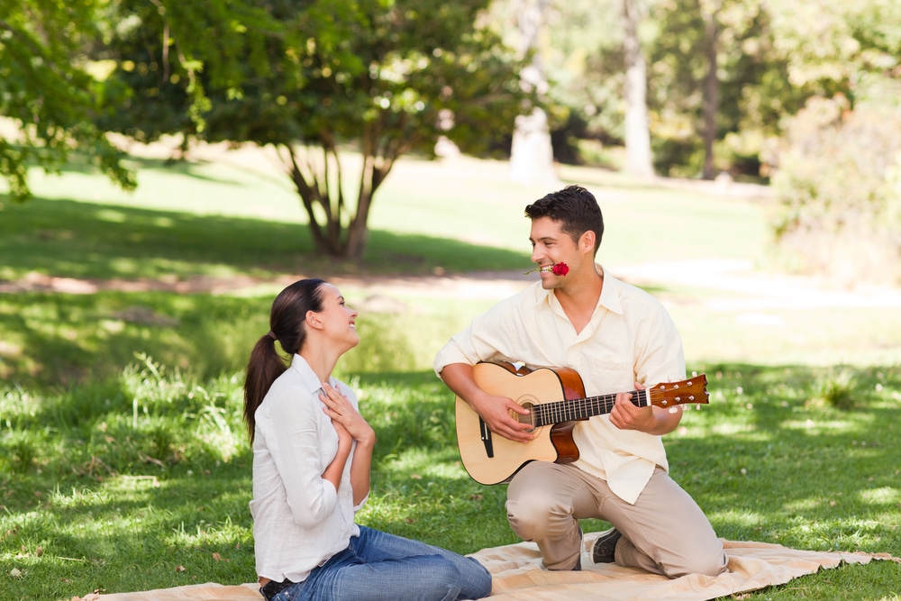man-serenading-a-woman-with-a-guitar-in-the-park