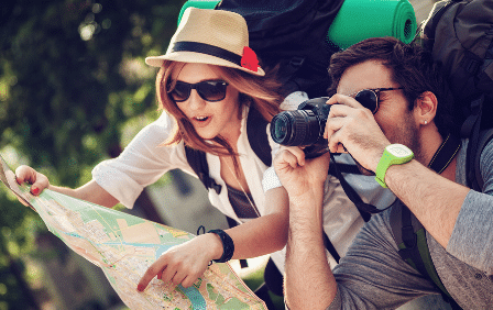 woman looking at map with man next to her taking photos with his camer