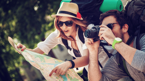 woman looking at map with man next to her taking photos with his camer