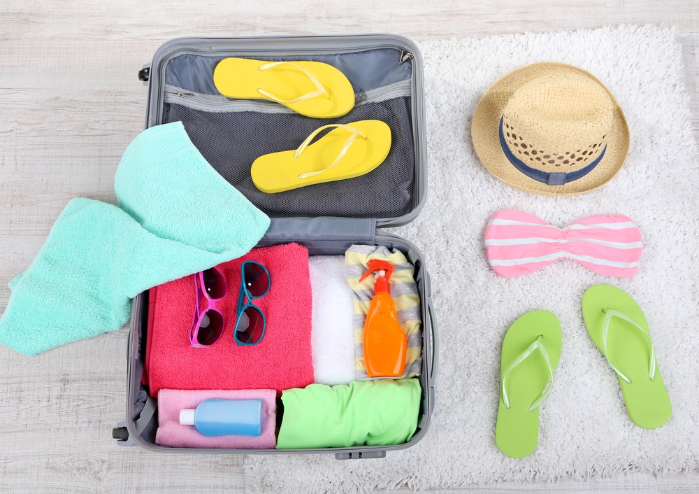 suitcase with beach clothes and accessories