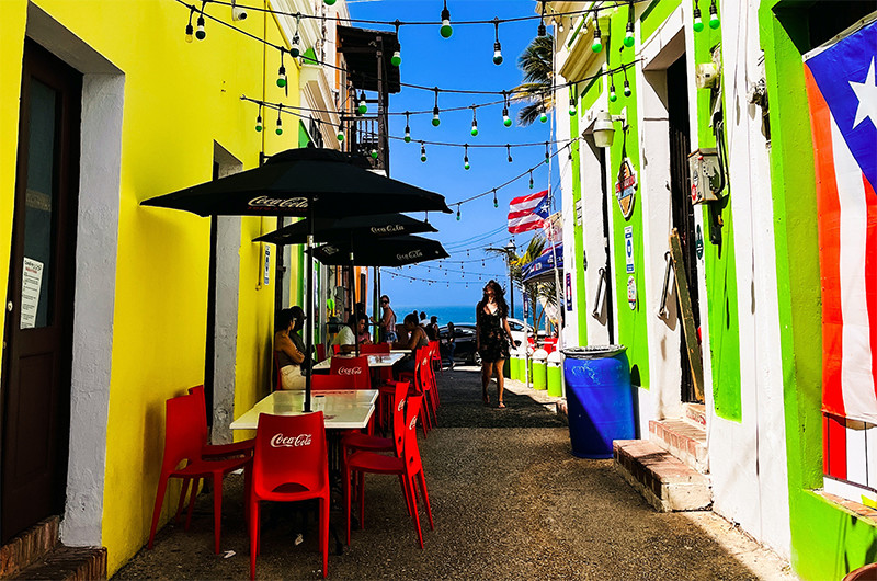 A colorful street with tables and chairs
