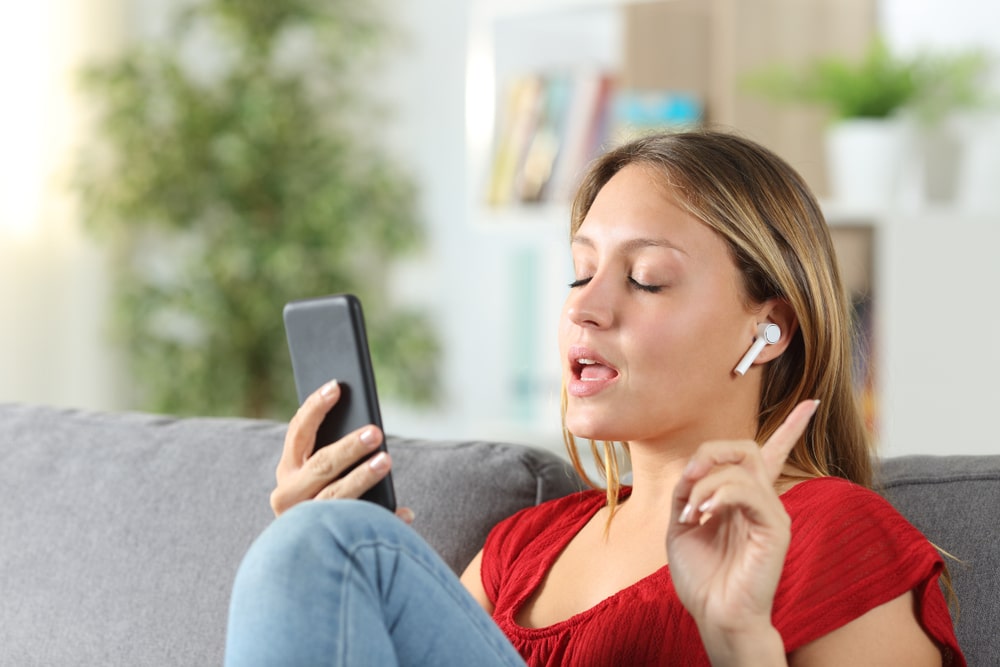 woman sitting on couch with headphones on the phone