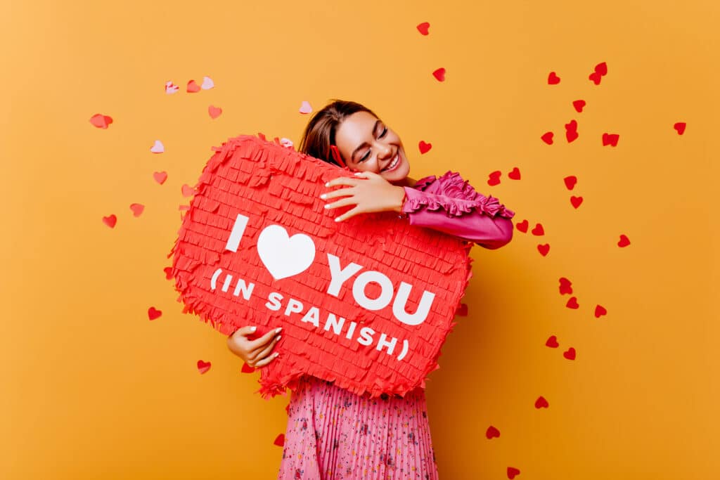 happy-woman-with-yellow-background-hugging-sign-that-says-i-love-you