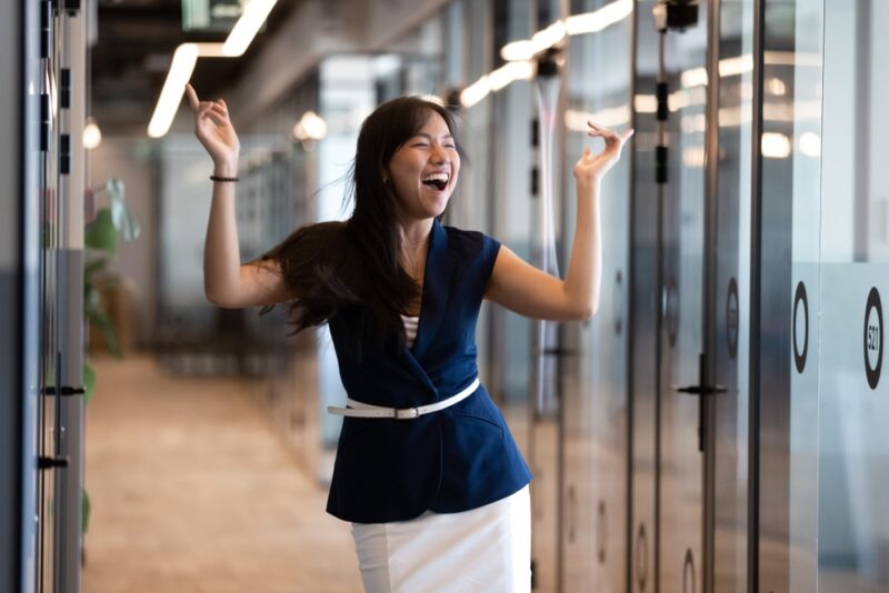 excited young asian business woman celebrating success