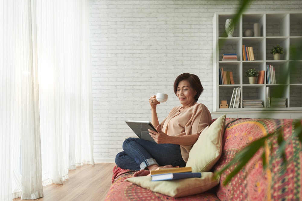 woman-drinking-coffee-and-reading-on-tablet