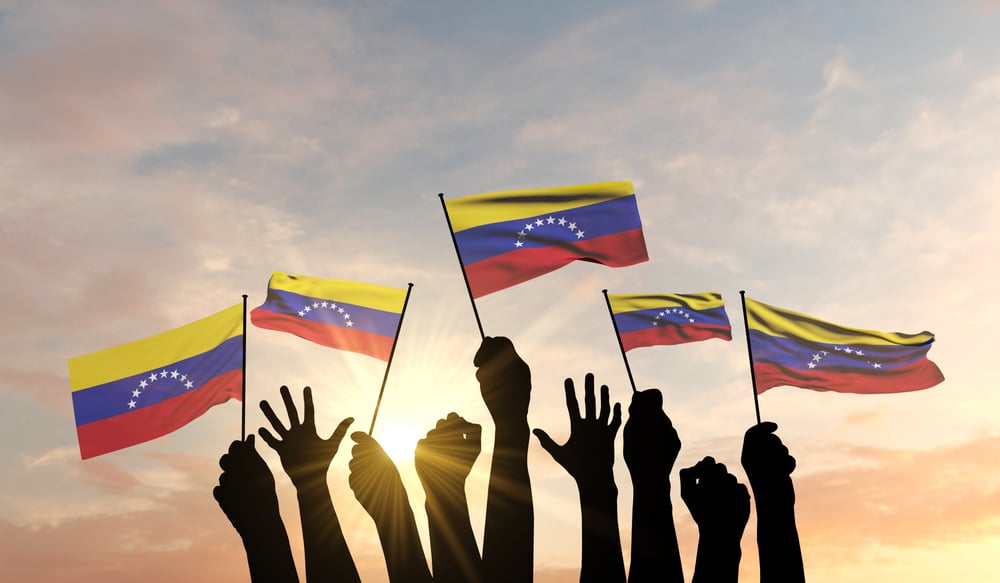 Silhouette-Of-Arms-Raised-Waving-Venezuelan-Flag