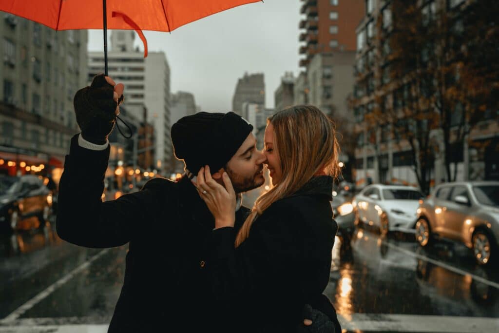 Couple kissing under an umbrella in the rain