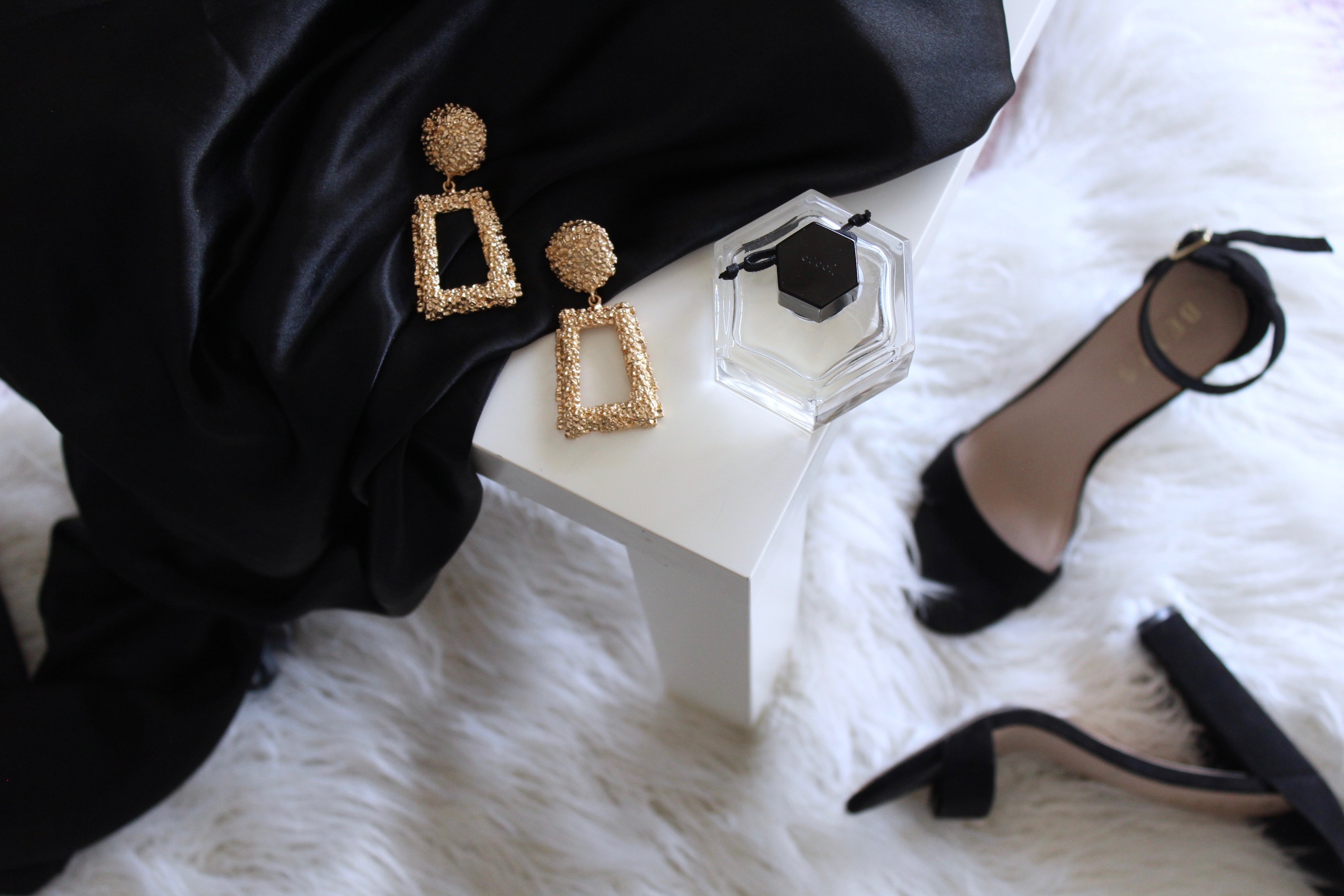 Luxurious fashion items laid out on a bed