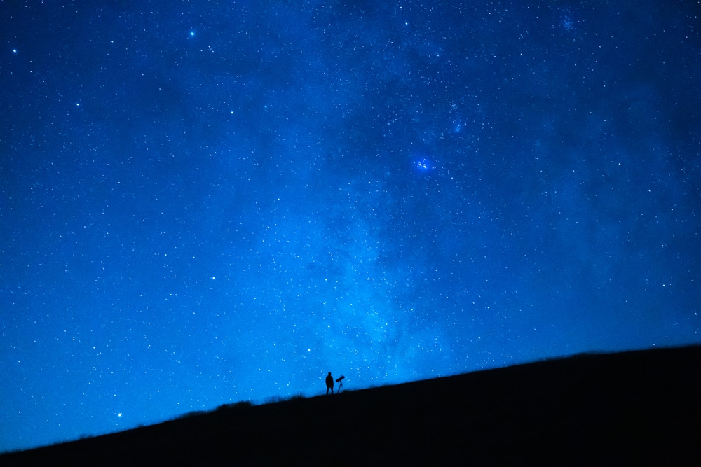 person-observing-starry-night-sky-with-telescope
