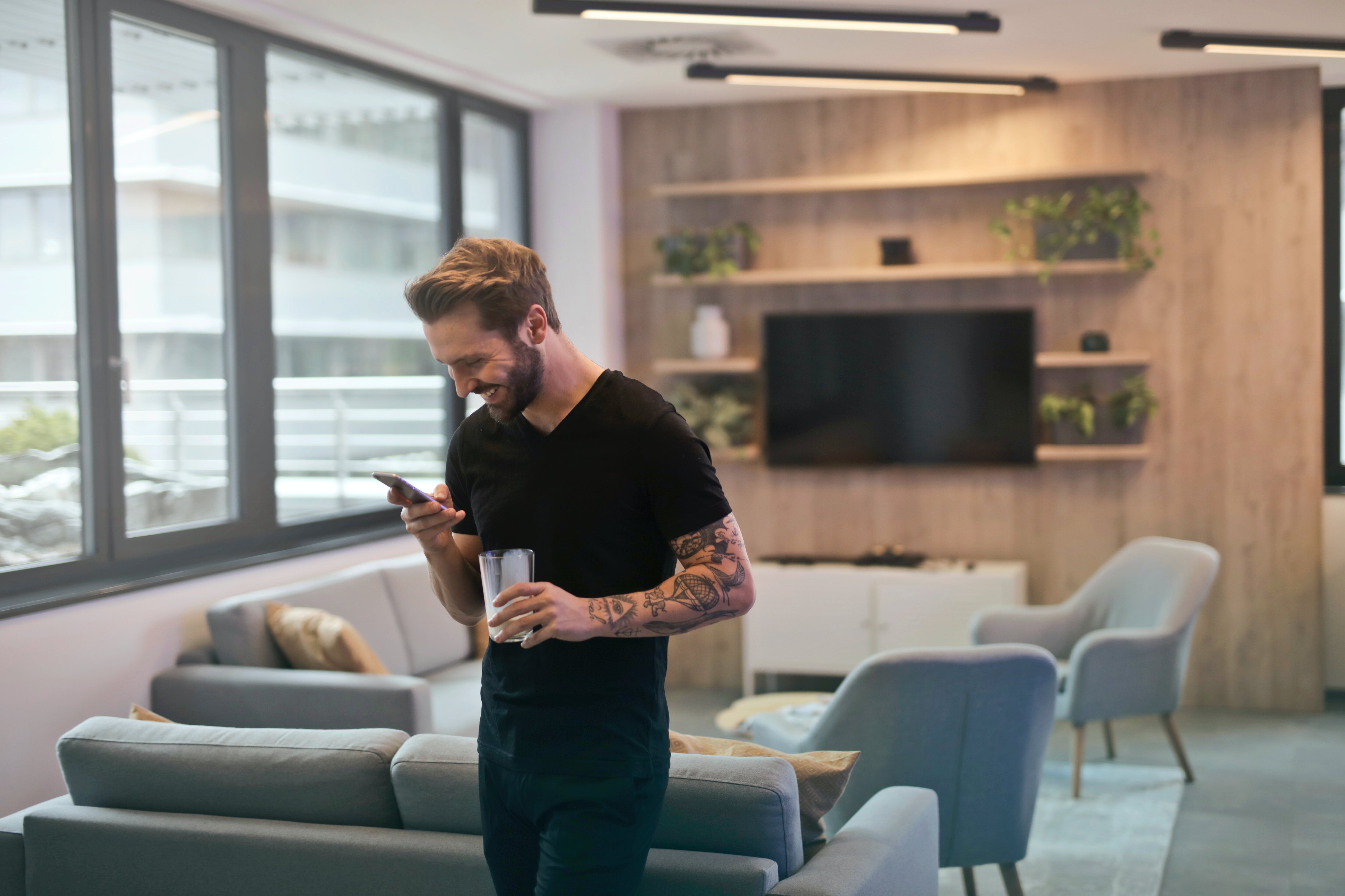 A man texts on his phone in an office