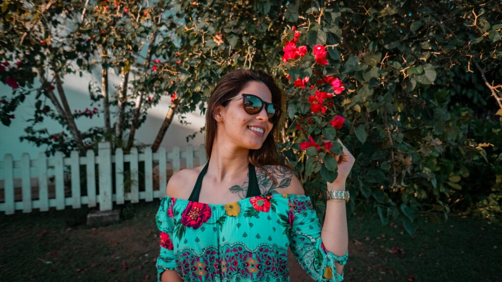 A smiling woman poses underneath a flowering tree