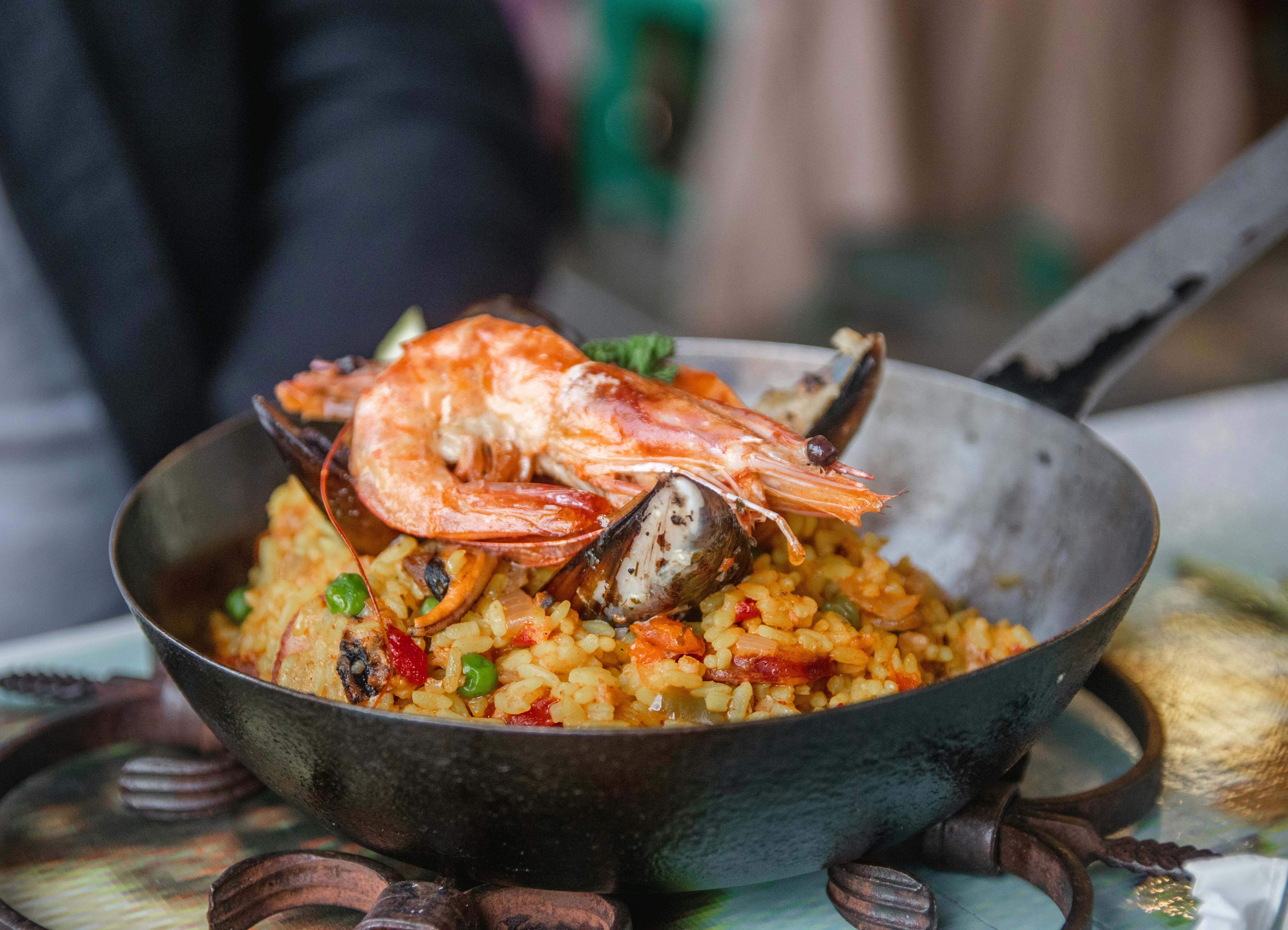 A paella is presented to diners in a cast iron pan