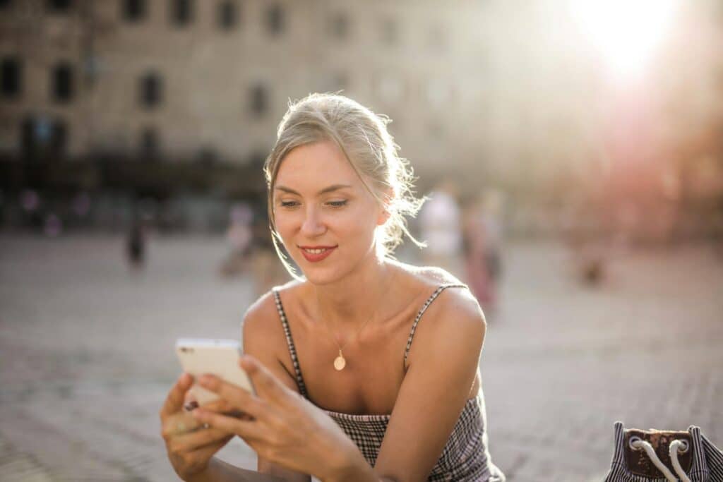 woman-smiling-happily-at-phone