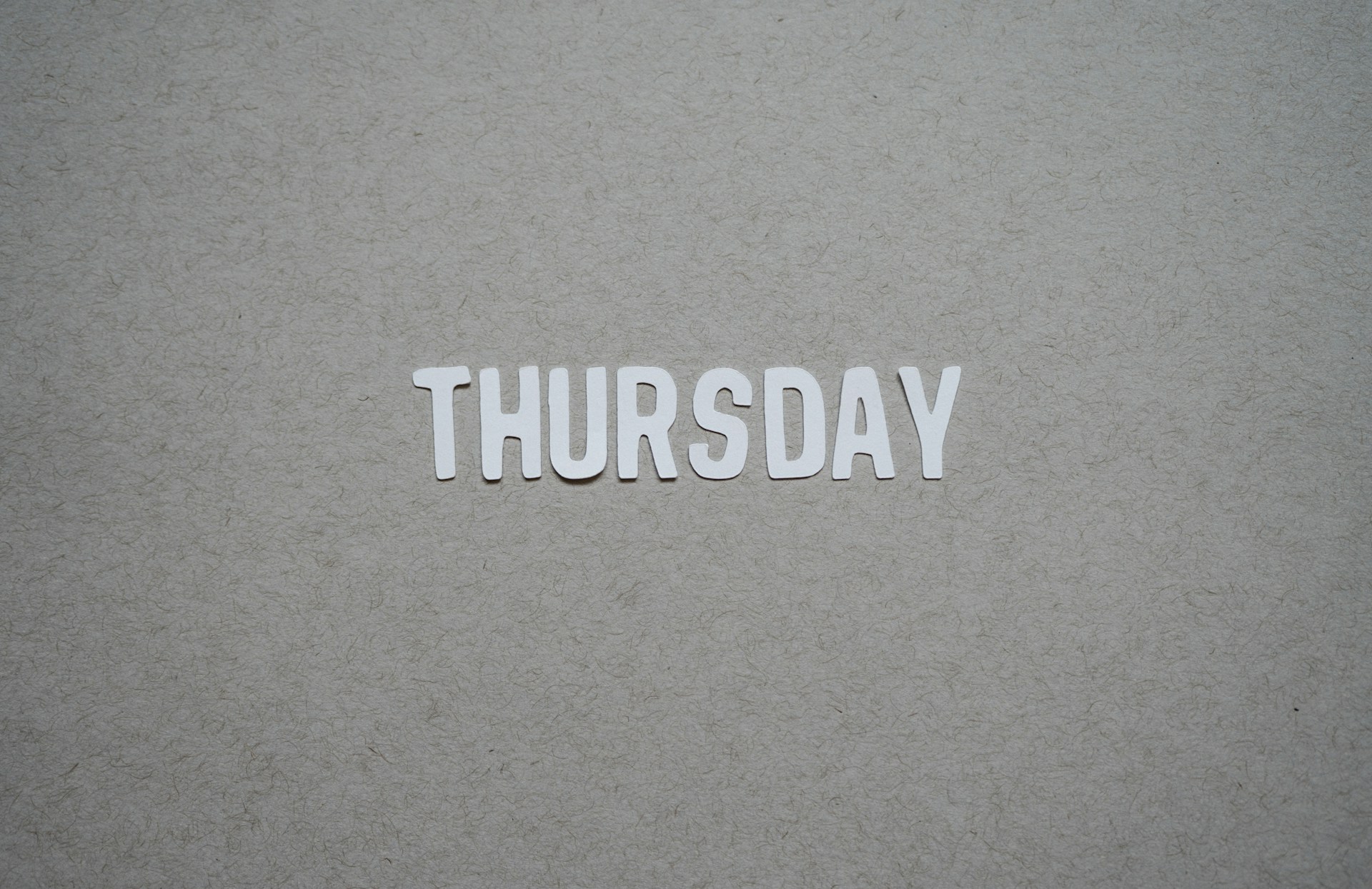 paper-cutout-of-the-word-thursday-against-gray-background