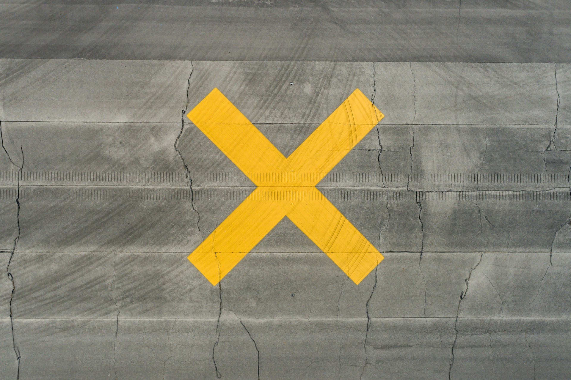 yellow-cross-sign-on-wooden-floor