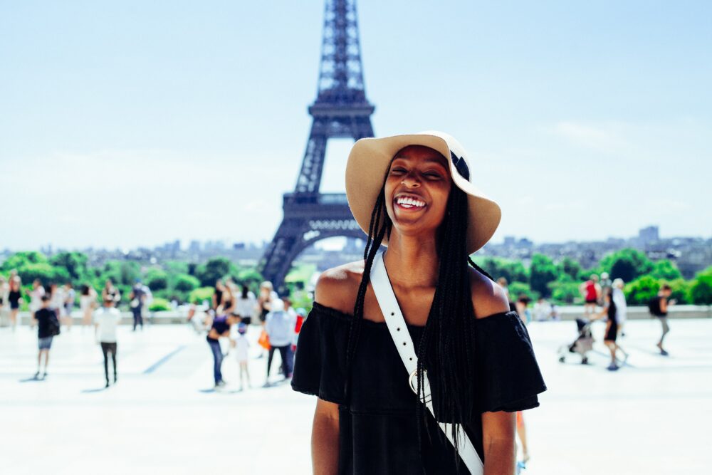 woman-standing-in-front-of-the-eiffel-tower-smiling