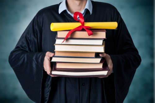graduate-holding-a-stack-of-books-with-a-diploma-on-top