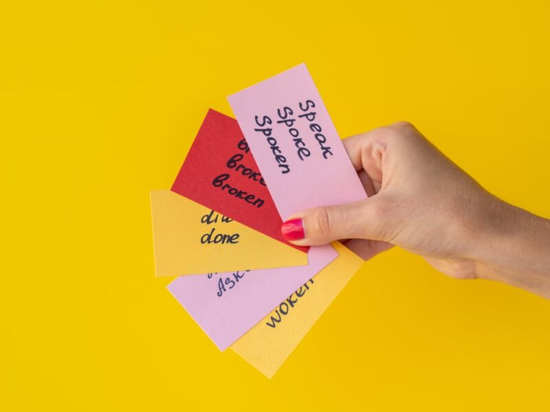 hand holding five foreign language flashcards against yellow background