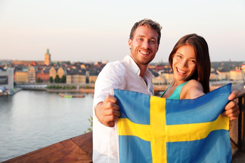 Two-people-holding-Sweden-flag-in-Stockholm