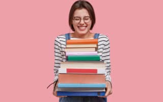 woman happily holding a stack of books