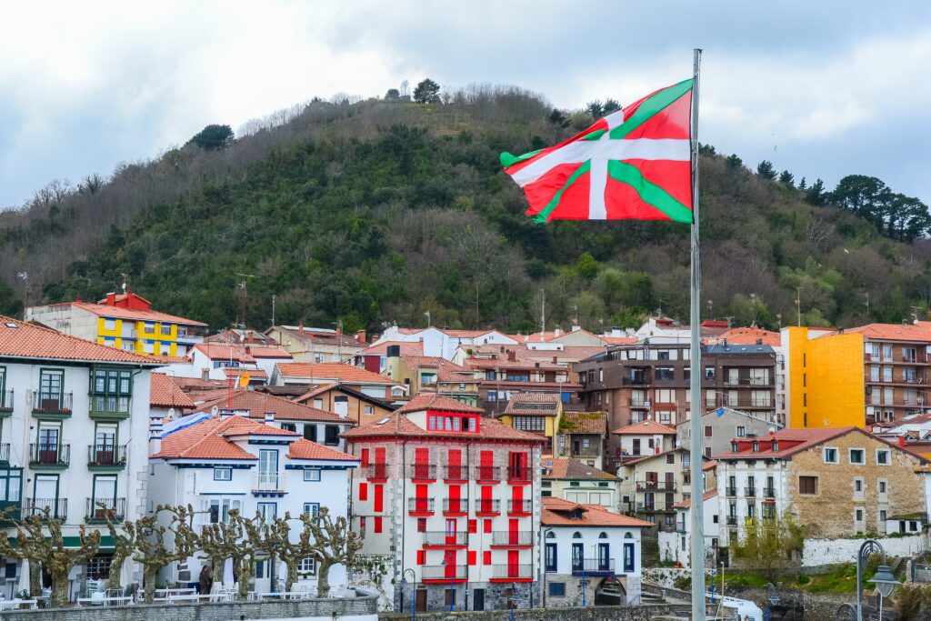 A Basque flag flying over a Basque seaside village