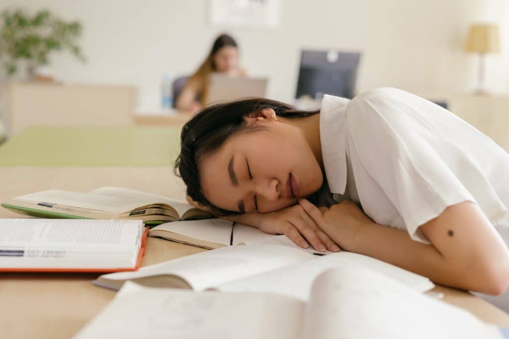 woman-of-asian-descent-sleeping-on-books
