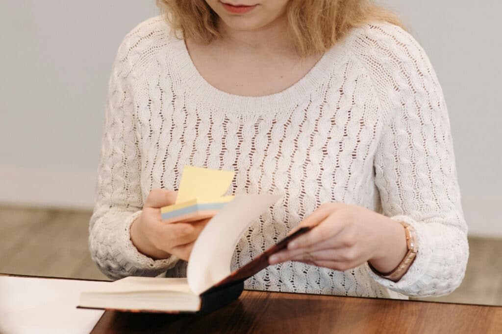 Woman holding post it notes and notebook