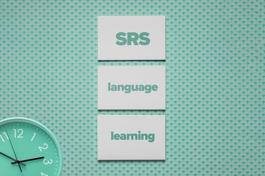 three flashcards with "SRS language learning" written on them against a mint green background