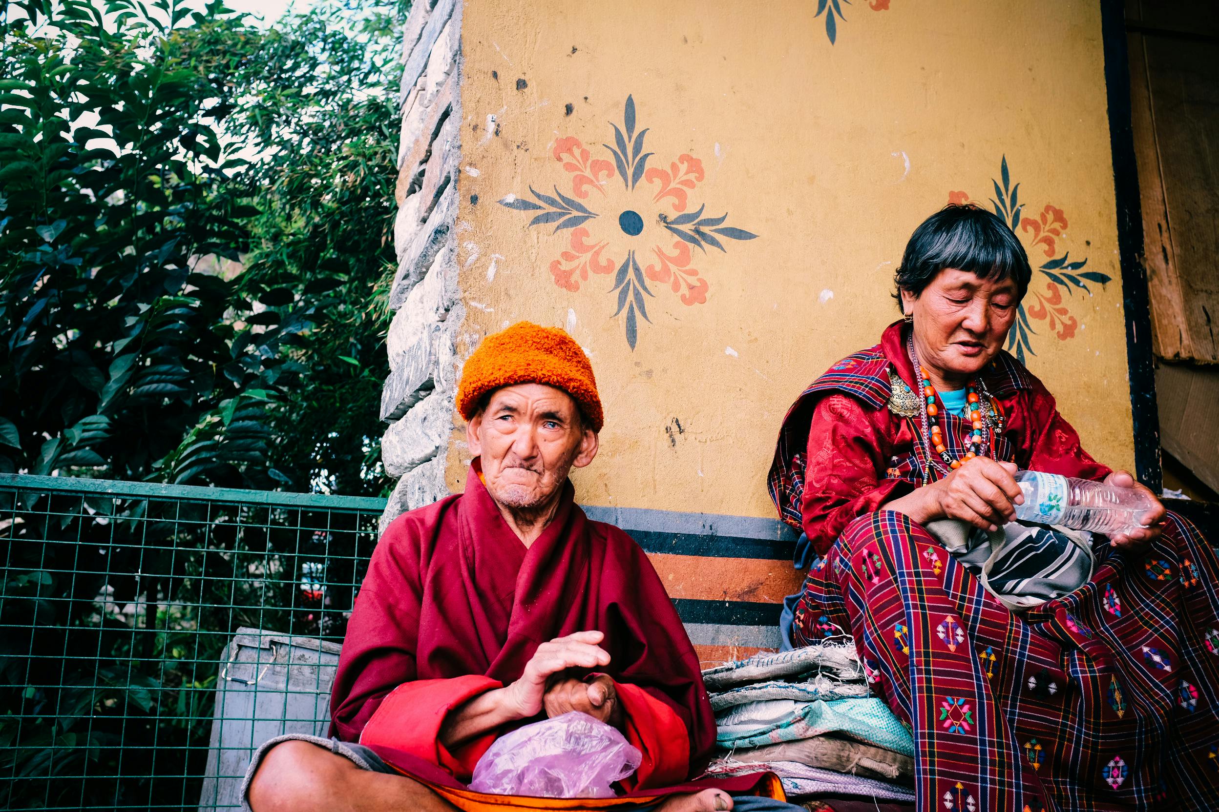 Two robed people sit together in Bhutan